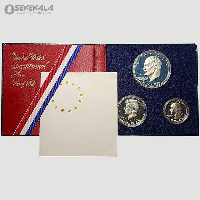coin collection store.www.sekekala.com040423 (82) این مجموعه سکه به مناسبت دویستمین سالگرد استقلال ایالات متحده (Bicentennial) در سال 1976 ضرب شده و شامل سه سکه نقرهای با کیفیت پروف است که در جعبهای قرمز رنگ با روکش مخملی و نوارهای سهرنگ (قرمز، سفید، آبی) عرضه میشود. سکهها شامل یک دلار، نیم دلار و ربع دلار هستند که هر یک طراحی منحصربهفردی دارند. سکه دلار با تصویر زنگ آزادی (Liberty Bell) و ماه در پسزمینه، سکه نیم دلار با تصویر ساختمان کنگره ایالتی ایلینوی، و سکه ربع دلار با تصویر کلنل ایزاک شلتون طراحی شدهاند. طراحی این سکهها توسط ست جی. هانتینگتون (Seth G. Huntington) و دننیس آر. ویلیامز (Dennis R. Williams) انجام شده و با تکنیک ضرب دوبل بر روی نقره صیقلی ایجاد شدهاند.