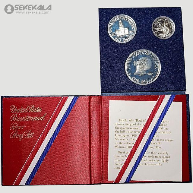 coin collection store.www.sekekala.com040423 (83) این مجموعه سکه به مناسبت دویستمین سالگرد استقلال ایالات متحده (Bicentennial) در سال 1976 ضرب شده و شامل سه سکه نقرهای با کیفیت پروف است که در جعبهای قرمز رنگ با روکش مخملی و نوارهای سهرنگ (قرمز، سفید، آبی) عرضه میشود. سکهها شامل یک دلار، نیم دلار و ربع دلار هستند که هر یک طراحی منحصربهفردی دارند. سکه دلار با تصویر زنگ آزادی (Liberty Bell) و ماه در پسزمینه، سکه نیم دلار با تصویر ساختمان کنگره ایالتی ایلینوی، و سکه ربع دلار با تصویر کلنل ایزاک شلتون طراحی شدهاند. طراحی این سکهها توسط ست جی. هانتینگتون (Seth G. Huntington) و دننیس آر. ویلیامز (Dennis R. Williams) انجام شده و با تکنیک ضرب دوبل بر روی نقره صیقلی ایجاد شدهاند.