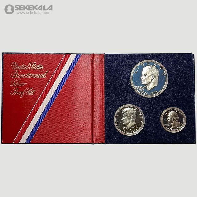 coin collection store.www.sekekala.com040423 (84) این مجموعه سکه به مناسبت دویستمین سالگرد استقلال ایالات متحده (Bicentennial) در سال 1976 ضرب شده و شامل سه سکه نقرهای با کیفیت پروف است که در جعبهای قرمز رنگ با روکش مخملی و نوارهای سهرنگ (قرمز، سفید، آبی) عرضه میشود. سکهها شامل یک دلار، نیم دلار و ربع دلار هستند که هر یک طراحی منحصربهفردی دارند. سکه دلار با تصویر زنگ آزادی (Liberty Bell) و ماه در پسزمینه، سکه نیم دلار با تصویر ساختمان کنگره ایالتی ایلینوی، و سکه ربع دلار با تصویر کلنل ایزاک شلتون طراحی شدهاند. طراحی این سکهها توسط ست جی. هانتینگتون (Seth G. Huntington) و دننیس آر. ویلیامز (Dennis R. Williams) انجام شده و با تکنیک ضرب دوبل بر روی نقره صیقلی ایجاد شدهاند.